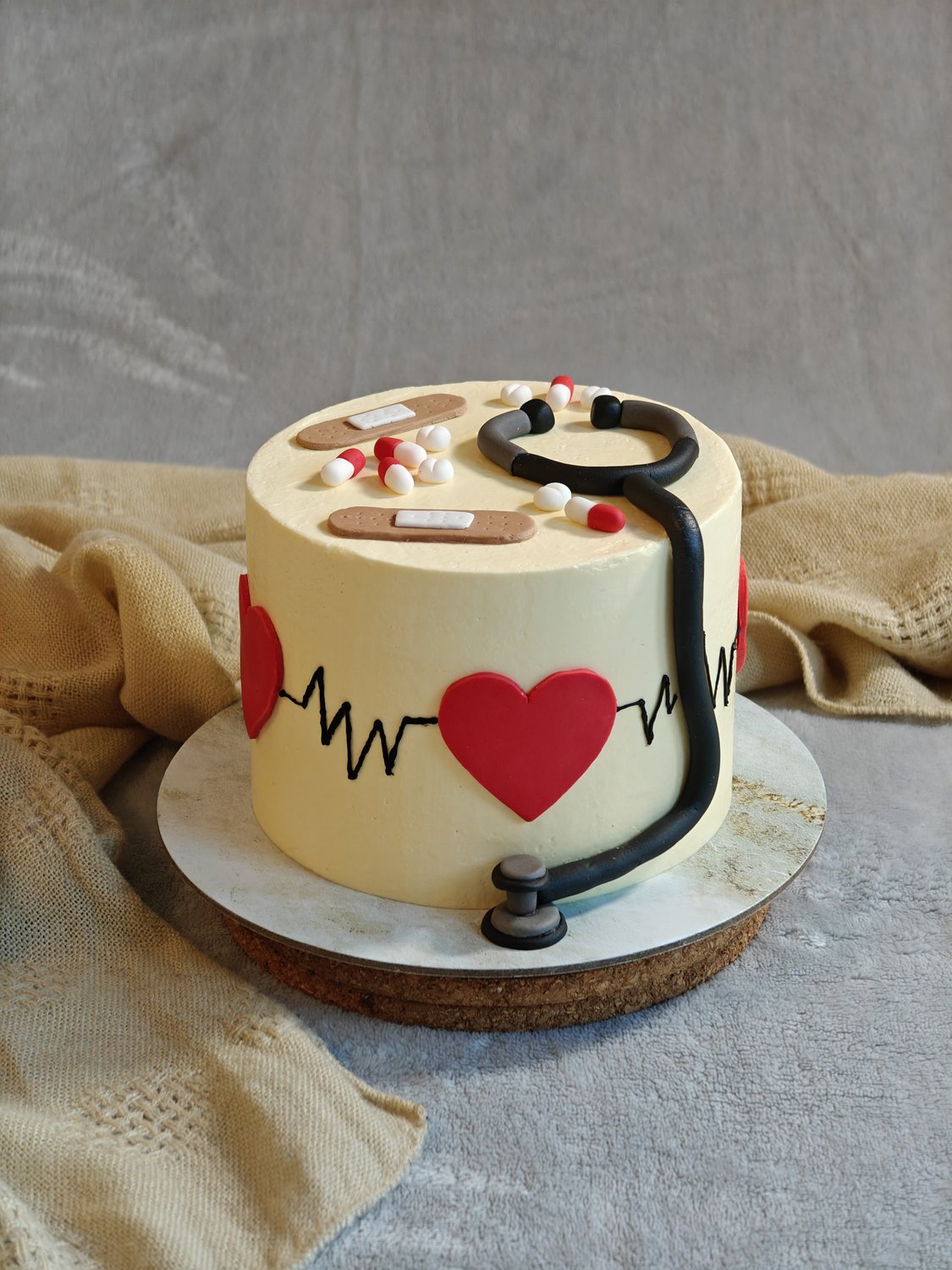 Doctor-themed cake with fondant stethoscope and heartbeat detail